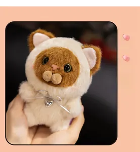 Detail of Siamese cat plush toy with heart pendant and silver bow on hand