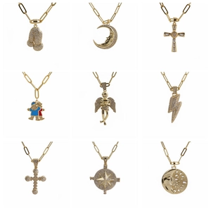 Close-up of nine gold paperclip necklaces featuring zircon-studded religious and celestial charms