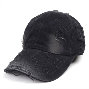 Detail of distressed brim and frayed edges on washed black cotton baseball cap