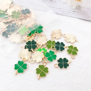 Detailed macro of green clover enamel charms with golden alloy edges for jewelry making