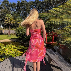 Vue arrière d'une robe fleurie bustier à volants sur une terrasse en bois de jardin