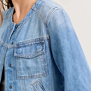 Close-up of light blue denim jacket collar and metallic buttons with detailed stitching