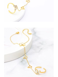 Détail de la bague bracelet papillon doré avec incrustation de nacre sur fond en marbre