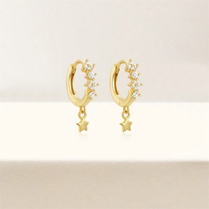 Close-up of gold star earrings with sparkling cubic zirconia flower inlay details