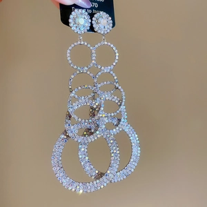 Close-up of sparkling silver tassel earrings with layered rhinestone rings and shiny finish