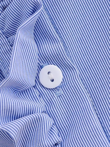 Macro detail of blue and white striped poplin shirt fabric with white button