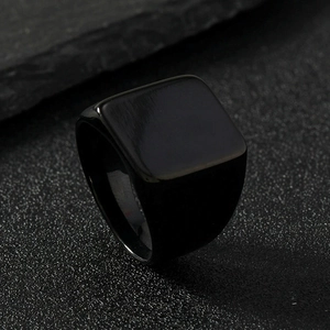 Macro detail of high-polish black stainless steel signet ring with a sleek square top surface