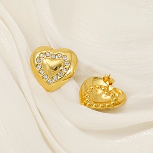 Gold-plated heart stud earrings with white zircon accents on white silk background