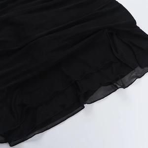 Detail showing layers of black mesh fabric on the split hem of the halter dress