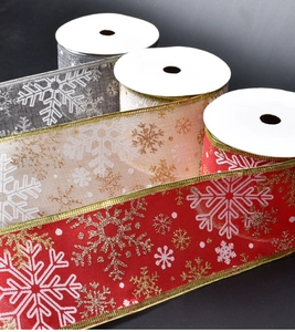 Detail of Christmas snowflake sheer ribbon with gold glitter edges in red, grey, and cream