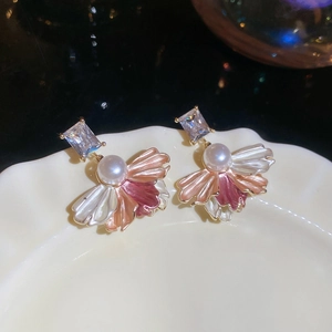 Detailed shot of gold plated earrings featuring pearls and multi-colored petal petals