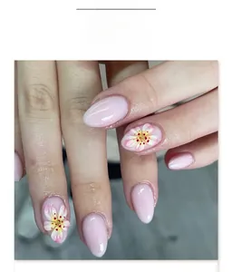 Close-up of short almond press-on nails with pink gradient and 3D cherry blossom floral art