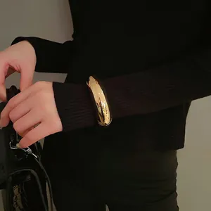 Minimalist thick gold open bangle with smooth round tube design for women