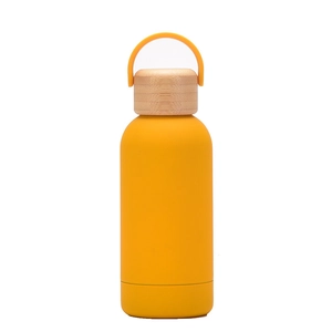 Detail of yellow insulated water bottle featuring a natural bamboo lid and sturdy handle
