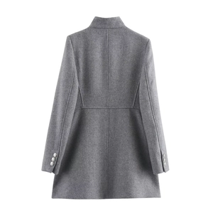 Detail of grey wool coat featuring slim waist cut and metallic buttons on the sleeves