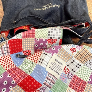 Detail of vintage patchwork bag showing floral prints, denim fabric, and woven labels