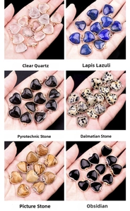 Macro shot of assorted heart-shaped gemstone pendants with metallic borders in hand