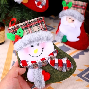 Vista dettagliata di una calza di Natale in peluche verde con design a pupazzo di neve