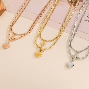 Detailed view of layered necklaces in rose gold, gold, and silver with star and heart pendants