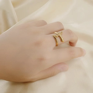 Modern 18K gold plated stainless steel sword hilt ring displayed on champagne silk fabric