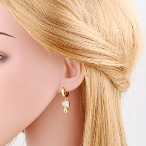 Detail of mushroom pendant gold earrings with pave white zircon on a model