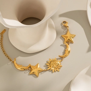 Detailed view of sun, moon and star charms on a gold-plated stainless steel bracelet
