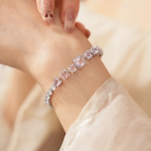 Detailed macro view of square pink zircon stones on a silver chain bracelet