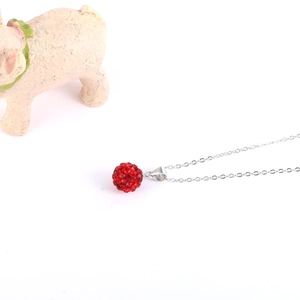 Nahaufnahme eines roten Shamballa-Kristallkugel-Anhängers an einer feinen Silberkette