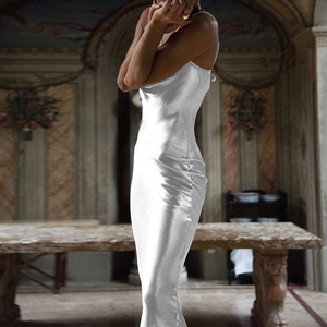 Detail of elegant white satin backless dress featuring a cowl neck and slim fit silhouette