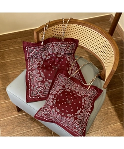 Detail view of red paisley tote bag with decorative bead handles and vibrant fabric texture