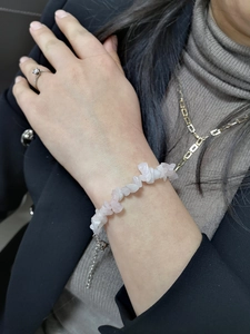 Close-up of a natural light pink crystal gravel bracelet worn on a female wrist