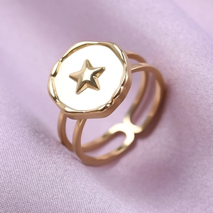 Macro shot of gold 18k plated star ring with white circular face and double-layer band