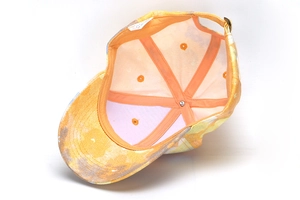 Internal view of tie-dye baseball cap featuring orange lining and adjustable metal buckle