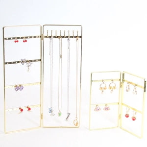 Golden folding screen jewelry stand for earrings and necklaces on white background