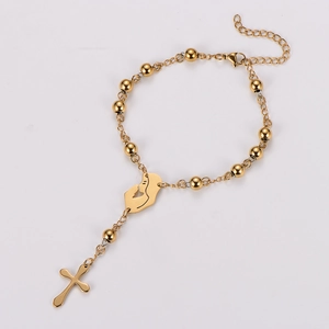 Detailed macro view of gold religious bead bracelet with cross and Virgin Mary charms