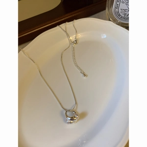Macro di una collana placcata in oro 18K con pendente traforato e perle incastonate