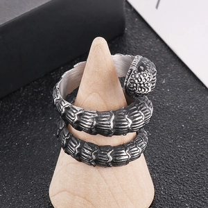 Detailed view of punk style snake ring with realistic scale texture on wood stand