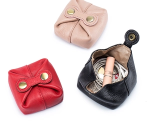 Detailed view of mini leather coin purses in red, pink, and black with snap closure