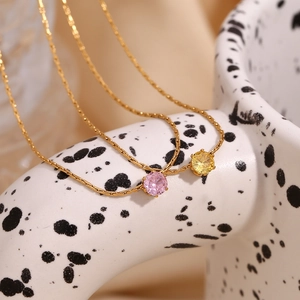 Macro shot of 18K gold plated woven necklaces with pink and yellow zircon pendants