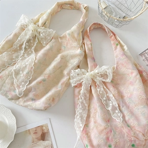 Detail of floral tote bags featuring delicate embroidery and large white lace bows