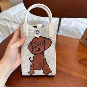 Détail d'un mini sac tricoté avec motif de chien et poignées en cuir blanc pour femme