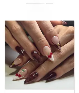 Close-up of 3D cherry design on almond press-on nails with tortoiseshell and gold accents