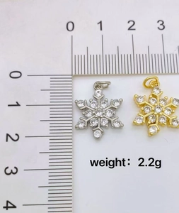 Macro shot of gold and silver snowflake pendants with zircons and size ruler details
