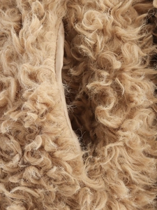 Détail de la texture en peau lainée synthétique de couleur chameau avec laine bouclée dense