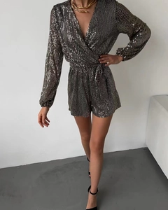 Detail of sequin long sleeve romper with deep V-neck and black gold stripe pattern