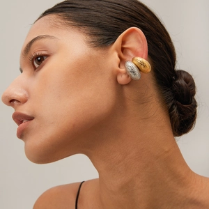 Detail of 18k gold and silver fish scale texture ear cuffs on a model side profile