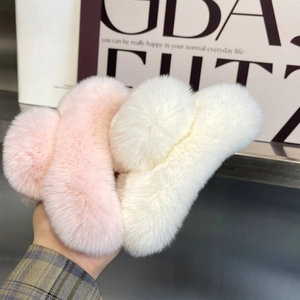 Handheld view of plush pink and off-white faux rabbit fur hair claws for winter