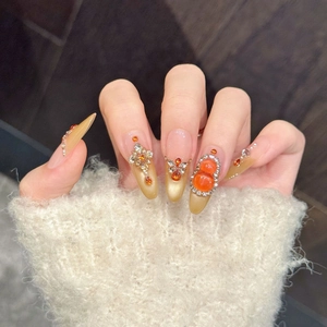 Luxurious champagne cat-eye press-on nails with amber rhinestones and 3D floral accents