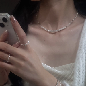 Detailed close-up of a s925 sterling silver pearl necklace and matching bracelet set