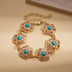 Detail of flower bracelet with green stones and sparkling crystals on golden links